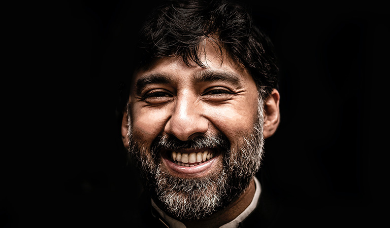 An image of a bearded man smiling