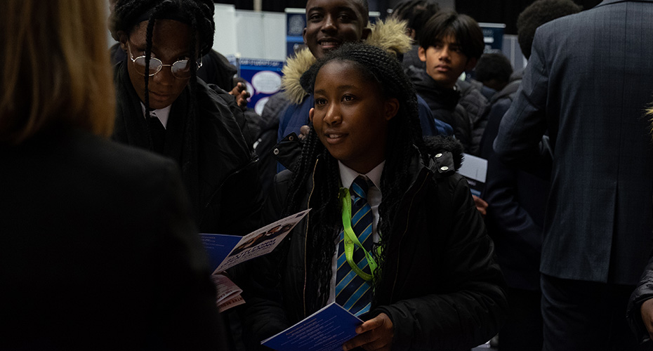 Young student speaking with an exhibitor at a an event