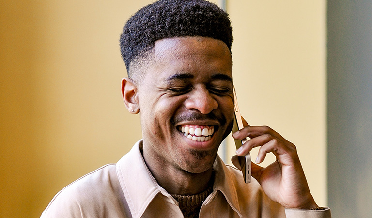 Man smiling whilst talking on a mobile phone