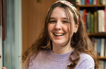 Woman smiling wearing a grey jumper