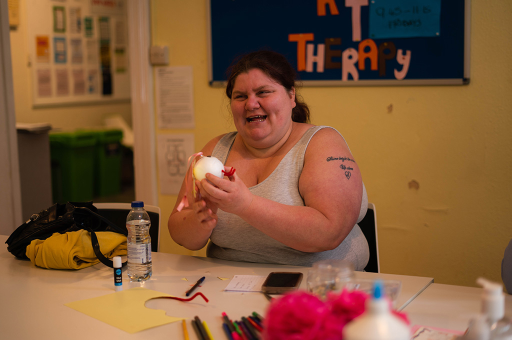 An image of a woman smiling in an arts and crafts session