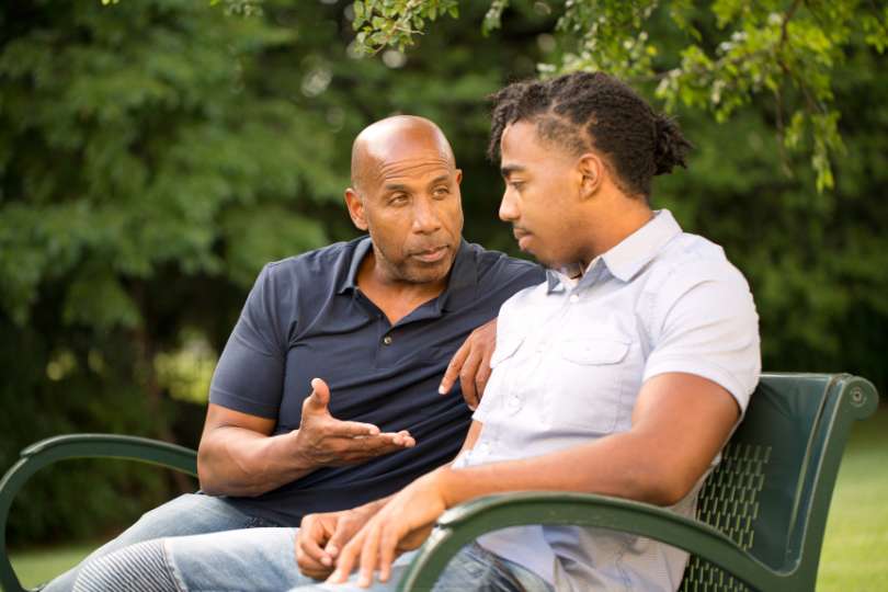 Male mentor talking to a young man.