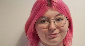 Leah Bailey - Pink hair, glasses and white jumper