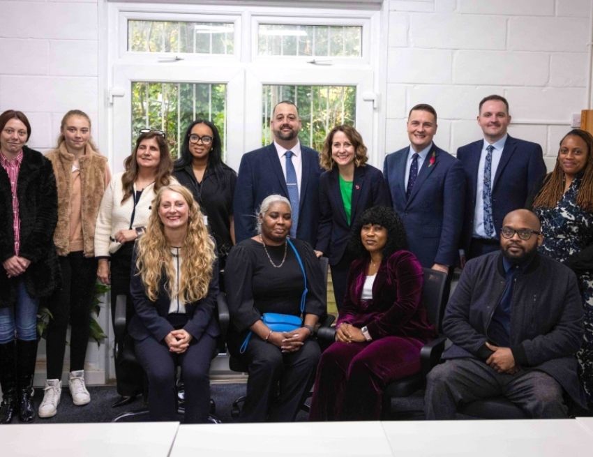 Group photo of visit including: Front seated: Sarah Morgan, Chief People Officer at North Central London ICB; Abegail Joseph-Spencer, Employment Specialist and participants Sandra and Christopher. Back right standing: Siobhan Scantlebury, Head of Employment Services, Islington Council Standing middle to right, Shaw Trust's Anthony Dandrea, Liz Kendall, Wes Streeting and Shaw Trust's David Harper. Standing middle to left, Shaw Trust's Mica Lawrence and Dr. Renu Hans, Clinical Director N2PCN & GP Partner Junction Medical Practice.