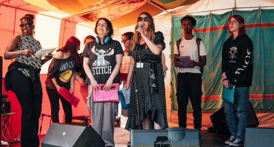 Participants performing on stage, signing.