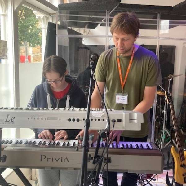 Two people playing a keyboard.