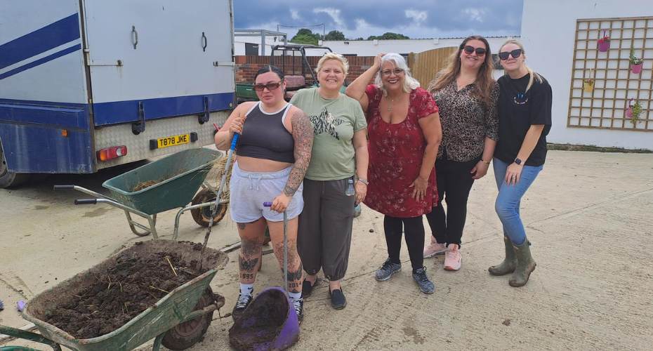 Group of people standing with a wheel barrow