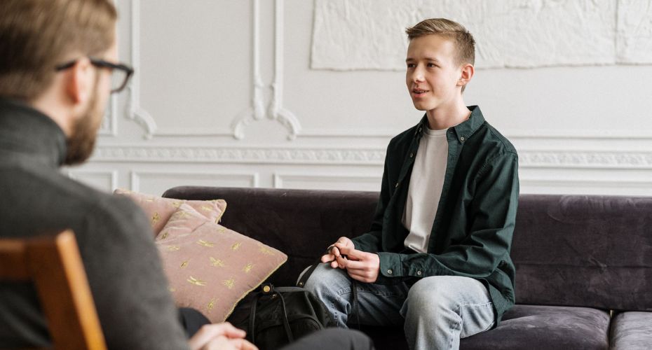 A young person sat on a sofa having a conversation