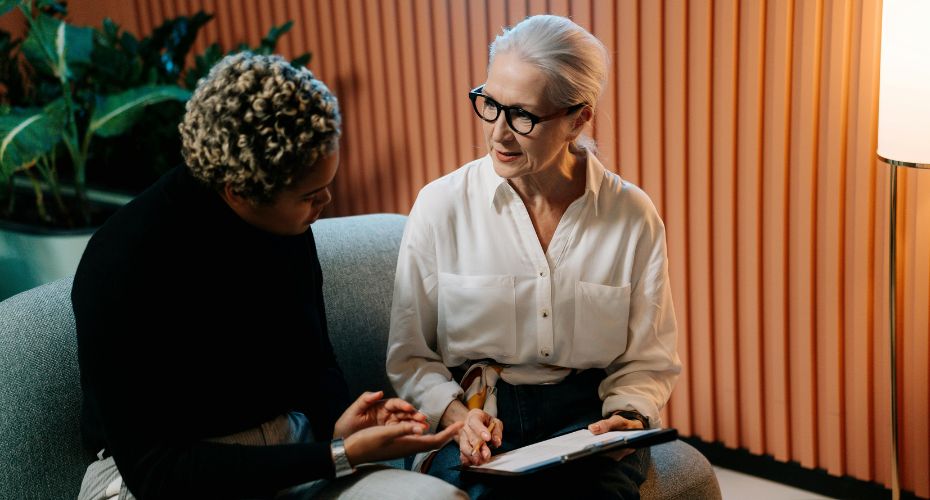 Two people sat on a sofa talking