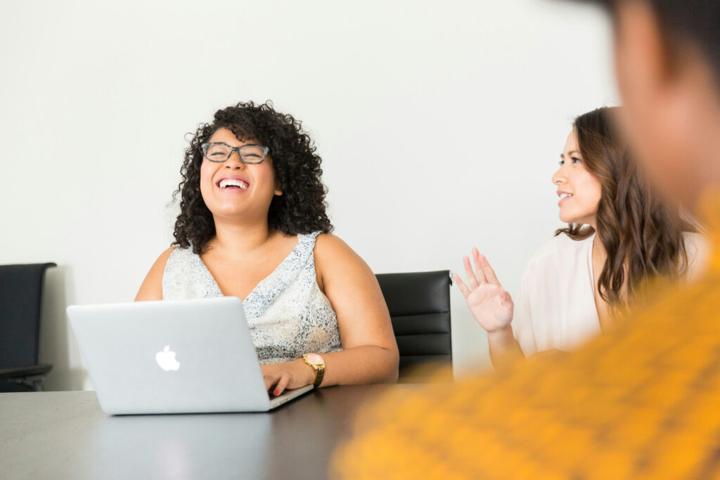 Woman smiling with apple mac in front of her