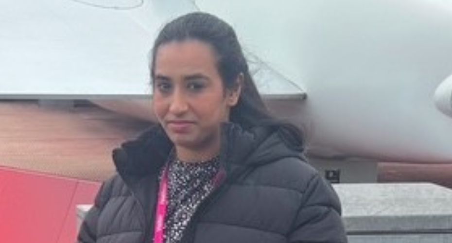 Esha standing wearing a coat