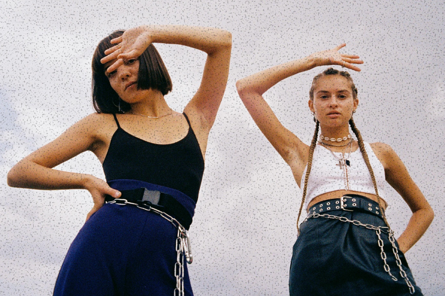 Two young people standing with arms in air