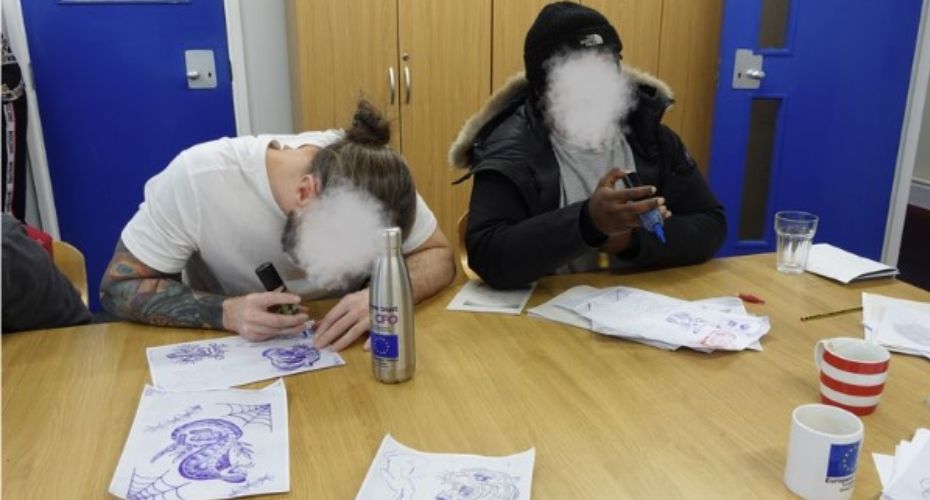 two people sat together drawing