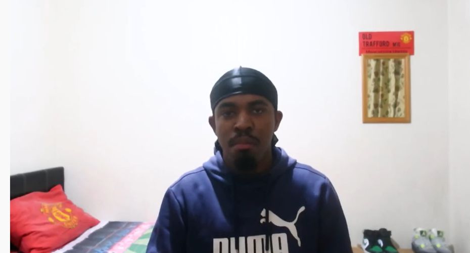 Man sat in a bedroom on a zoom call