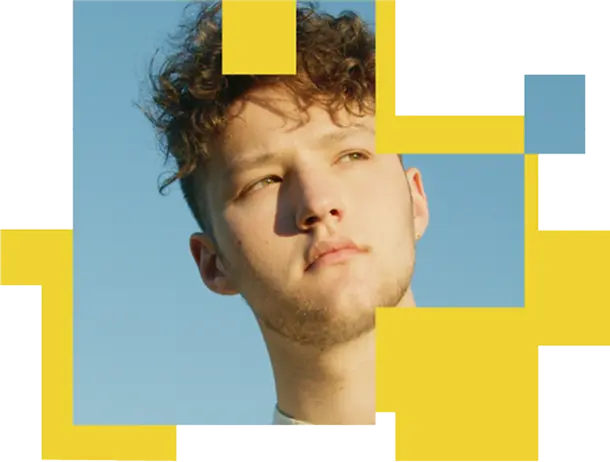 a young man with curly hair and stubble