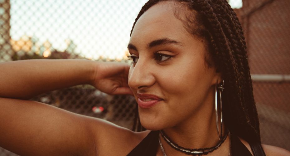 A woman smiling looking into the distance.